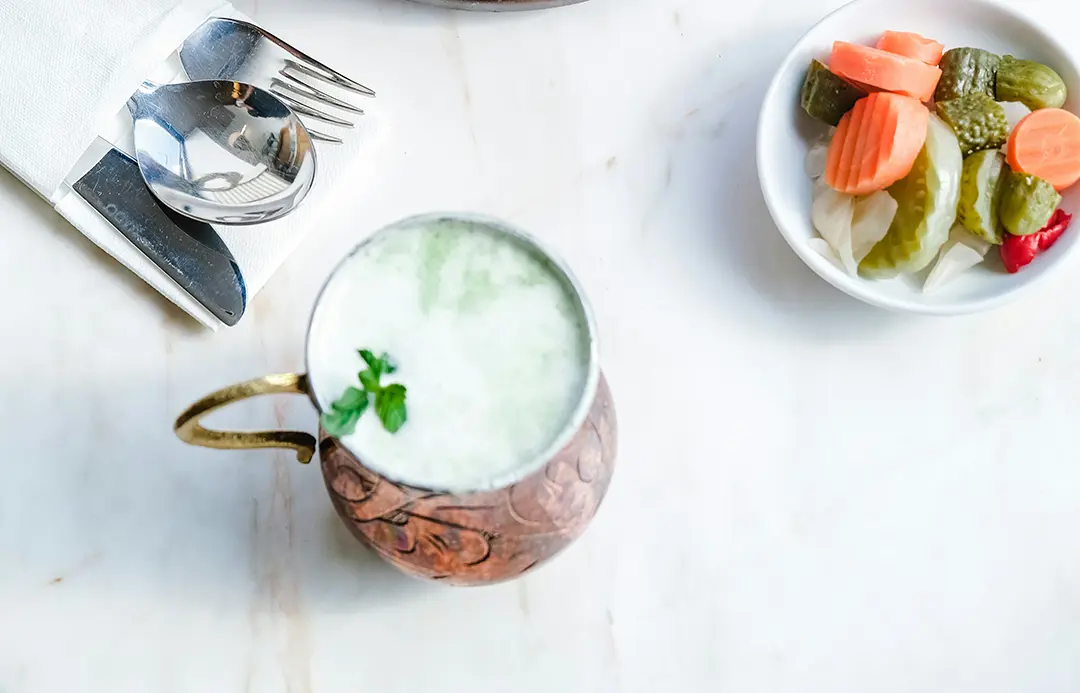 Yoghurt drink with mint and a plate of pickles
