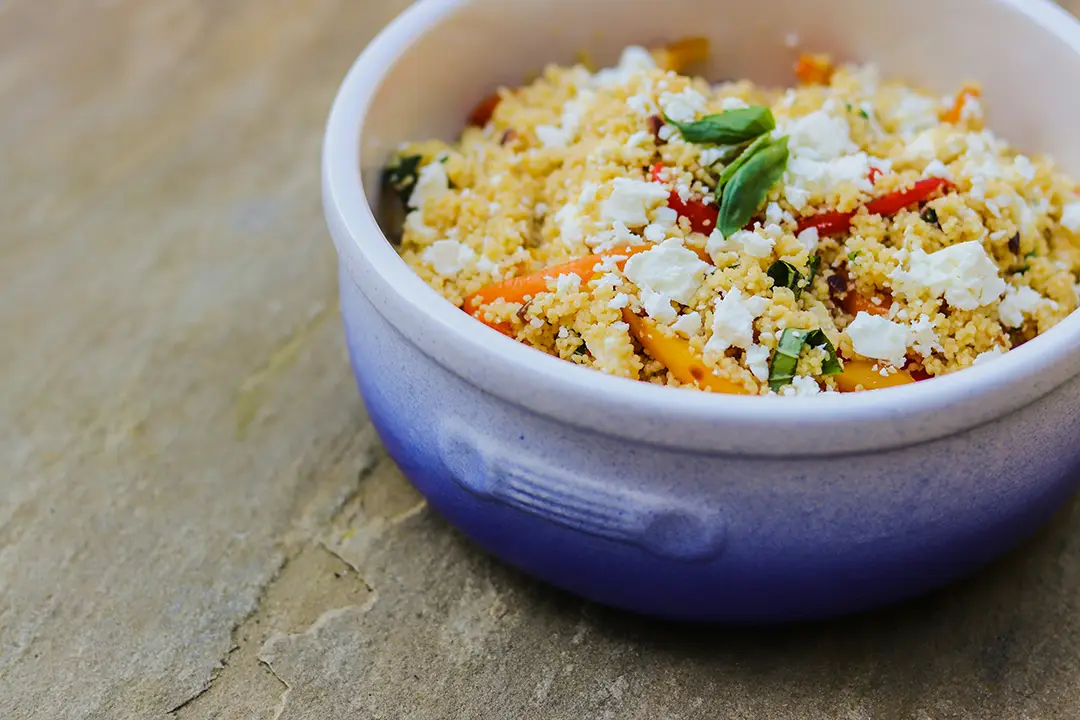 Bowl of colourful couscous salad with feta.