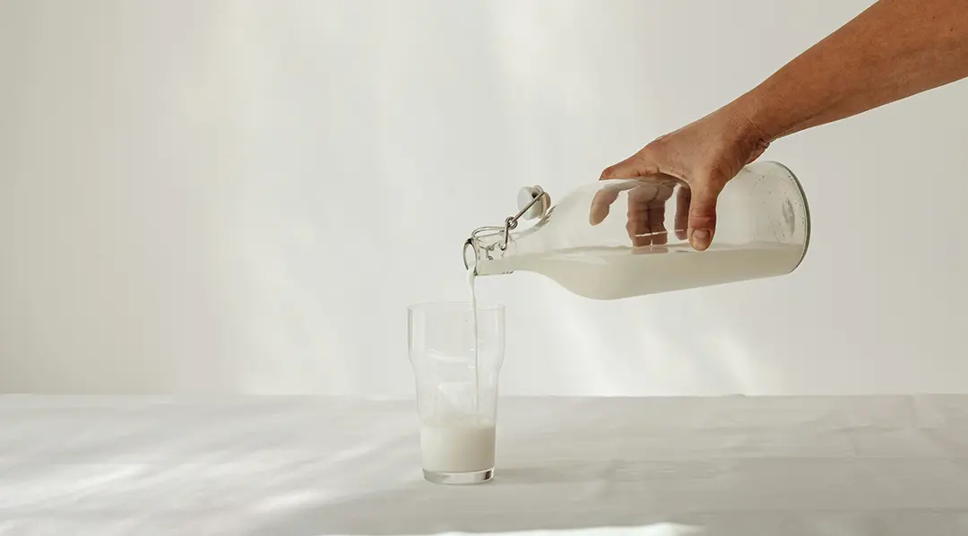 Pouring milk from bottle into glass