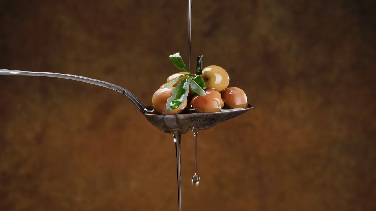 Spoon with olives and oil dripping