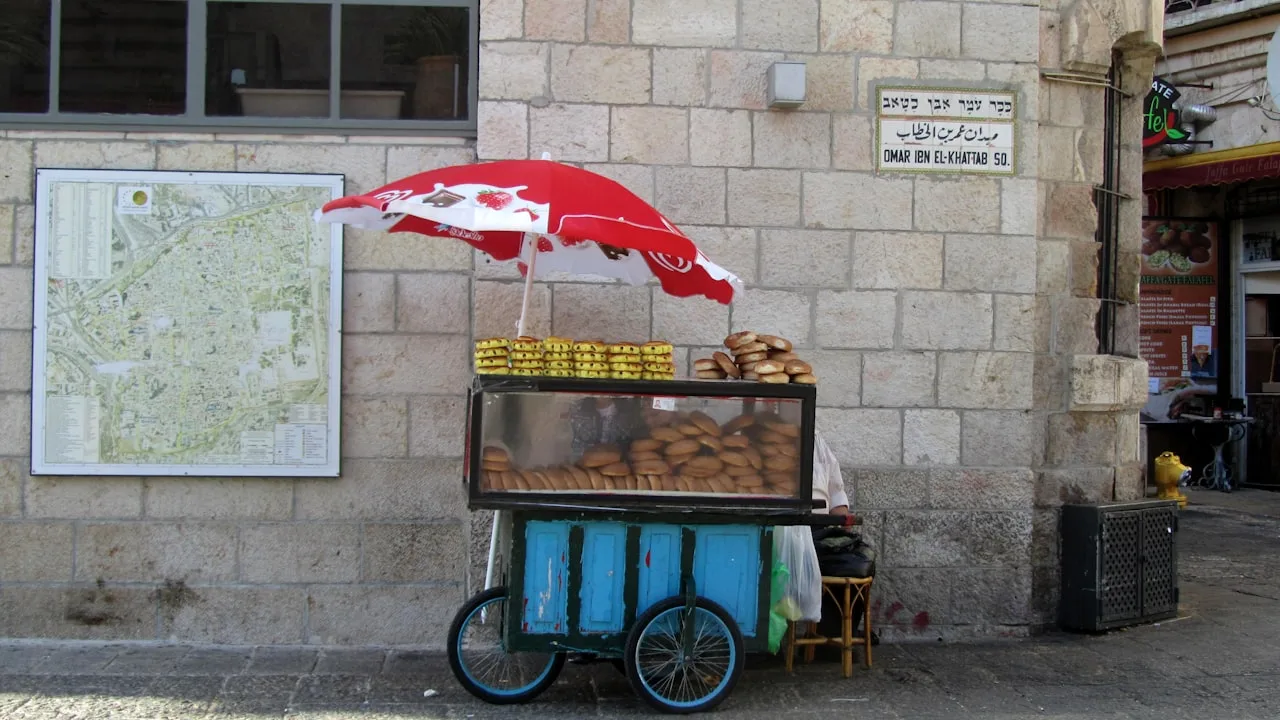 Street bread vendor under red umbrella