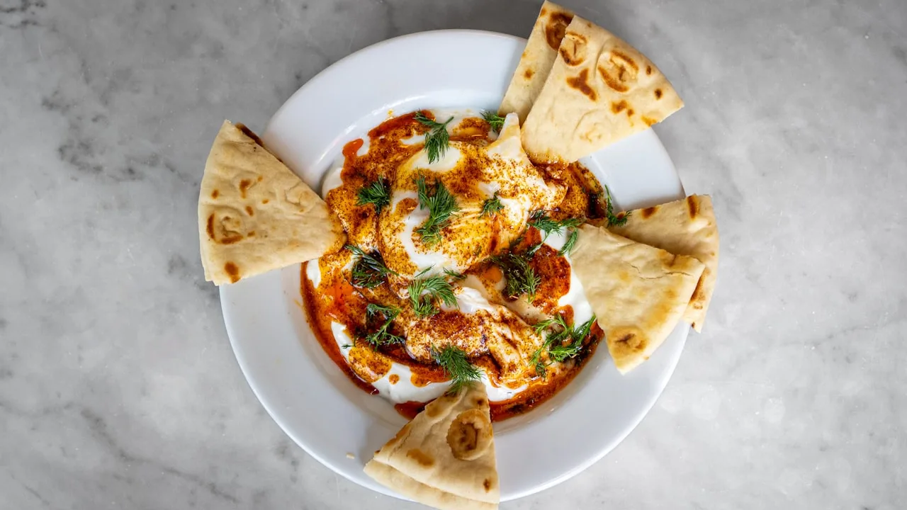 Dish with creamy eggs and flatbread.