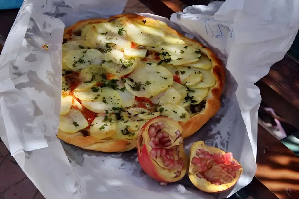 Pizza with sliced potatoes and tropical fruit.