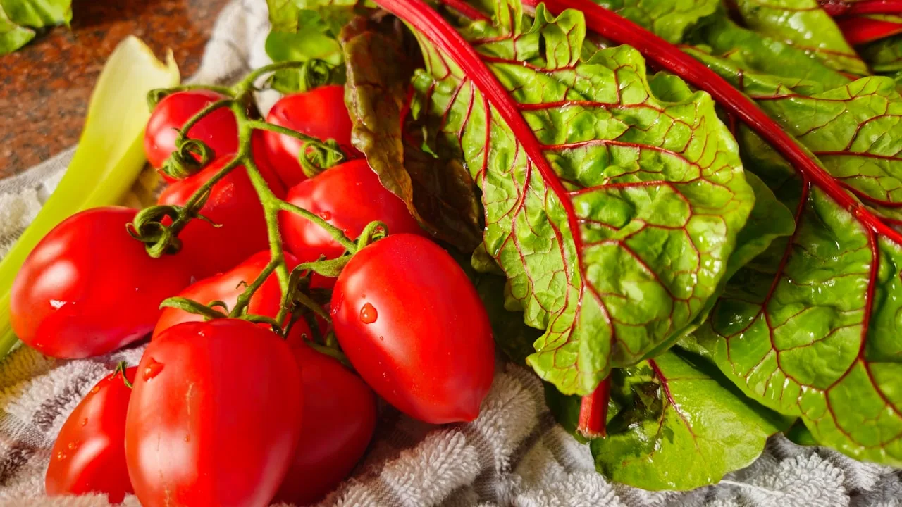 Fresh tomatoes and Swiss chard on cloth