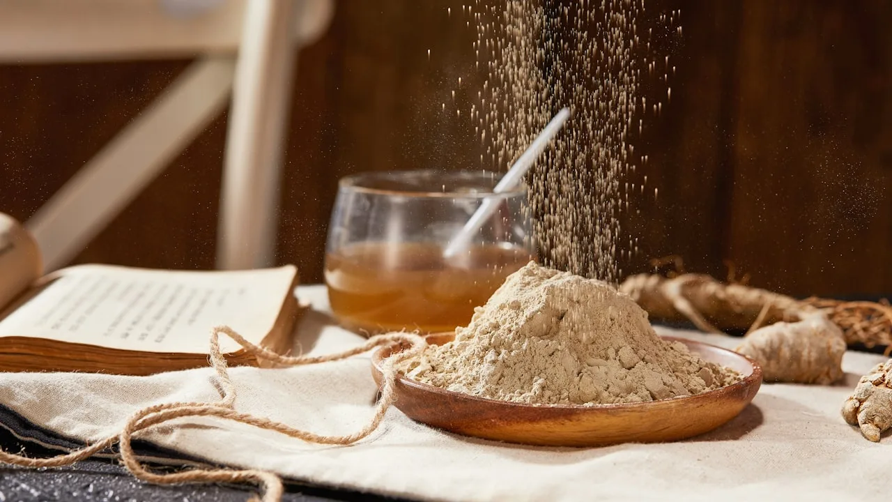 Ground ginger powder falling onto wooden plate